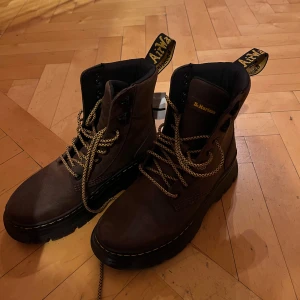 Bruna boots från Dr. Martens - Säljer ett par robusta bruna boots från Dr. Martens med grov sula och snörning. De har den klassiska gula sömmen och en praktisk dragflik baktill. Perfekta för en tuff och stilren look! Helt nya då jag köpte de när jag bodde i USA men de var för små🥲 Bruna färgen säljs inte längre 