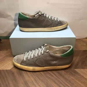 Grå Philipe models med gröna detaljer - Snygga gråa Philipe models med gröna detaljer på hälen. Skorna är i bra skick och låda följer ej med. Kontakta vid minsta intresse. Pris går att diskuteras