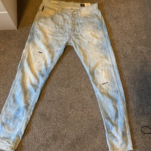 Ljusa jeans från Jack & Jones - Snygga ljusa jeans från Jack & Jones med slitna detaljer. De har en klassisk femficksdesign och knappgylf. Inga skador ⚡️