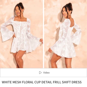 Vit blommig klänning från PrettyLittleThing - Säljer en superfin vit meshklänning från PrettyLittleThing med blommigt mönster och volangdetaljer. Klänningen har långa ärmar och en söt knytning framtill. Perfekt som studentklänning!💕Den är aldrig använd utan bara provad, säljer då jag valde en annan studentklänning☺️