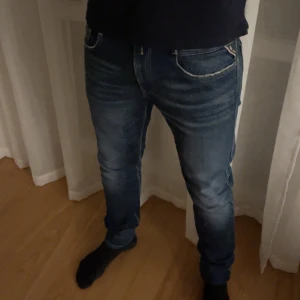 Blå jeans från Replay anbass - Snygga blå jeans från Replay anbass med klassisk femficksdesign och broderade bakfickor. Jeansen har en slim passform och är tillverkade i ett stretchigt denimtyg för extra komfort. Perfekta för en stilren look. Orginal priset när jag köpte dem var 2200kr och nu säljer jag endast för 650kr alltså mindre än halva priset! Dem är i perfekt skick och sitter jätte snyggt! Rekommenderar dessa till 100%! Storleken är    W34-L32! Kan gå ner i pris vid snabb affär! Skriv vid några funderingar!