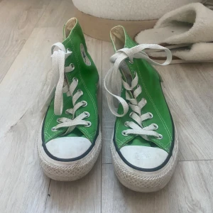 Gröna Converse sneakers - PRIS GÅR ATT DISKUTERA!! Säljer ett par gröna Converse sneakers med klassisk hög modell och vita snören. Storlek 36. Ganska bra skick, lite smutsiga men inga hål eller så. Skriv för fler bilder.💕