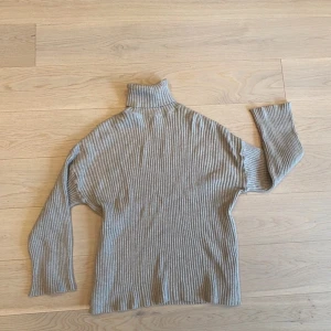 Beige ribbad polotröja - Säljer en stilren beige polotröja med ribbad struktur. Tröjan har långa ärmar och en hög polokrage som ger extra värme. Perfekt för kyligare dagar. Använd få gånger. Vänligen läs min bio innan du gör ett köp; där hittar du bland annat information om leveransprocessen med mera 😊