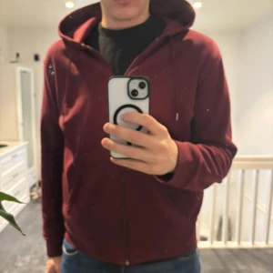 polo ralph lauren  - Säljer en vinröd hoodie med dragkedja och huva. Perfekt för en avslappnad stil. Den har långa ärmar och en bekväm passform. Passar bra till både jeans och träningsbyxor.