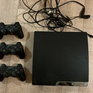 PlayStation 3 med tre kontroller - Säljer en PlayStation 3 från Sony med tre trådlösa DualShock 3-kontroller. Konsolen är svart och kommer med nödvändiga kablar. Perfekt för spelkvällar med vänner eller familj! Två av dessa kablar är dessutom laddare till kontrollerna. Pris kan diskuteras!