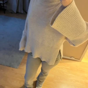 Beige stickad tröja - Mysig beige stickad tröja med polokrage och långa vida ärmar. Perfekt för kyliga dagar med sin avslappnade passform och ribbade detaljer vid ärmslut och nederkant. Helt ny från Gina köptes för 400kr säljs för 150kr