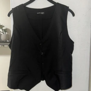 Svart väst från Shein - Snygg svart väst från Shein med knappar framtill och två fickor. Perfekt för att ge en stilren touch till din outfit.