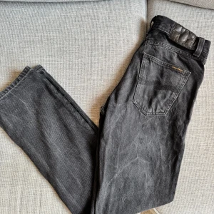 Nudie Jeans W27 - Säljer ett par klassiska svarta jeans från Nudie Jeans i slim fit. Jeansen är näst intill oanvända och köptes förra året för 1600. De är i storlek 27/30, och modellen heter Gritty Jackson och tvätten är Worn Circle. Skriv om du har frägor!