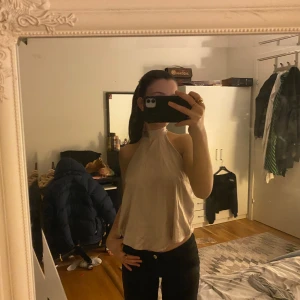 Beige halterneck topp - Snygg beige halterneck topp med öppen rygg och knytband i nacken. Perfekt för en stilren och elegant look.💕(pris går alltid att diskutera)