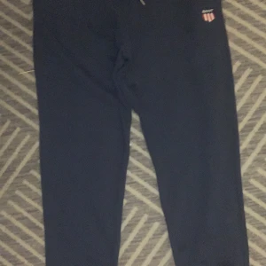 Byxor märkes - Snygga svarta mjukisbyxor från Gant med en liten logga på sidan. Perfekta för en avslappnad stil. Byxorna har en bekväm passform och är gjorda i mjukt material. Köptes för cirka 1000kr och har knappt använts