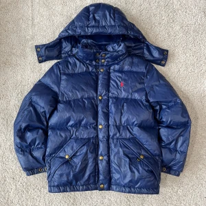 Ralph Lauren Puffer Jacka - En superskön och fin pufferjacka i nästan nyskick från ralph lauren. Den har inga defekter, är jättevarm och har en avdragbar luva! Storlek: 10-12 men passar cirka 150-165сm.