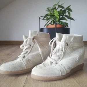 Isabel Marant liknande skor - Snygga beige sneakers i mocka med kilklack och snörning. Perfekta för en stilren look med en twist. De har perforerade detaljer för extra stil och komfort.