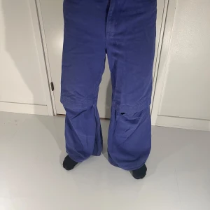 Blå byxor från H&M Studio - Snygga blå byxor från H&M Studio AW2021. Byxorna har en loose passform och är tillverkade i ett mjukt material. Perfekta för en avslappnad stil.