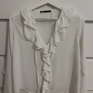 Vit zara blus - Jag säljer en jättefin volangblus från zara. Den är använd ett fåtal gånger och har inga defekter. Den finns ej att köpa på hemsidan längre. Pris går att diskuteras💕