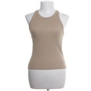 Beige ribbad linnetopp - Snygg beige ribbad linnetopp med rund halsringning. Perfekt för varma dagar eller som lager under en jacka. Enkel och stilren design som passar till det mesta.