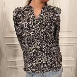 Mönstig blus - En superfin mönstig blus med knappar som går ner, vilket gör att man kan ha på sig den på massor av olika sätt. Den är aldrig använd och köpt i Holland så fåtal kan ha likadan. 