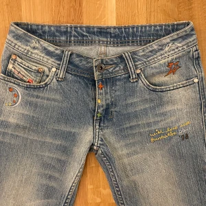 Lågmidjade diesel jeans - skiit snygga lågmidjade jeans med så snygga detaljer från Diesel. Strl 26, midjemått 36,5 cm innerbenslängd 79cm. Kan inte skicka bild när jag har på mig de, då de ej passar!