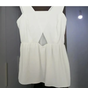 Vit ärmlös topp med cut-out detalj - ZARA - Snygg vit ärmlös topp med en unik cut-out detalj framtill. Perfekt för varma sommardagar eller en utekväll. Toppen har en luftig passform och är tillverkad i ett lätt material.