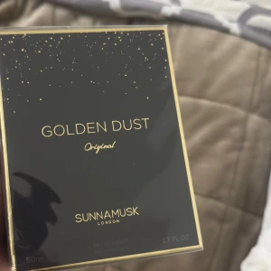 Sunnamusk Golden Dust Original - Golden Dust Original från Sunnamusk är en lyxig parfym i en elegant svart förpackning med gyllene detaljer. Flaskan rymmer 50 ml och har en sofistikerad doftprofil som passar perfekt för den som söker något unikt och exklusivt. Säljs för 900kr
