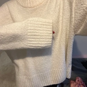 Vit stickad tröja - Mysig vit stickad tröja med ribbade detaljer vid ärmslut och nederkant. Perfekt för kyliga dagar och ger en stilren look. Passar bra till både jeans och kjol.  Ull 8%