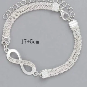 Silver armband med oändlighetssymbol - Elegant silverfärgat armband med en oändlighetssymbol dekorerad med små glittrande stenar. Armbandet har en justerbar kedja för perfekt passform. Perfekt för att ge en stilren touch till din outfit.