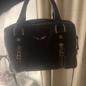 Svart sunny bag från zadig - Säljer min svarta sunny bag då den inte kommer till användning. Vissa nitar har blivit missfärgade ( som man kan se på bilderna) men syns inte i verkligheten. Skriv för frågor eller mer bilder💕, kan även mötas upp i Stockholm . Priset kan diskuteras 