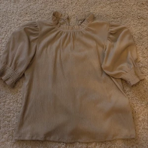 Beige Bluse  - Superfin Beige Bluse med lite puffärmar. Perfekt att ha i skolan eller till jobbet 