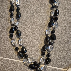 Svart och transparent halsband - Elegant halsband med svarta och transparenta pärlor i olika former. Perfekt för att ge en stilfull touch till din outfit. Det är från de danska designer märket Tomato 