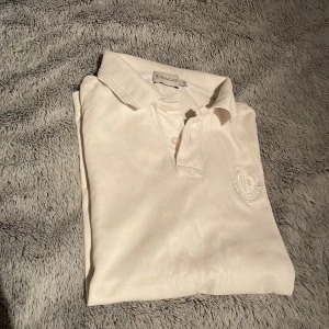 Vit pikétröja från Moncler - Vit moncler piké i storlek L i bra skick. Den passar även M/S.