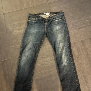 Blå jeans från J.Lindeberg - Snygga blå jeans från J.Lindeberg med klassisk femficksdesign och dragkedja. Perfekta för en avslappnad stil med en touch av elegans. Passar bra till både sneakers och kängor.