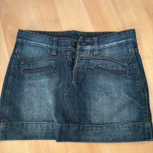 Jeanskjol med fickor - Snygg jeanskjol i klassisk blå denim med två framfickor och bälteshällor.