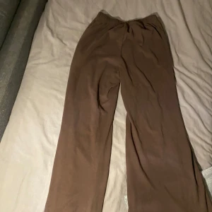 Bruna mjukisbyxor - Säljer ett par bekväma bruna mjukisbyxor med elastisk midja. Perfekta för en avslappnad dag hemma eller en lugn promenad. Byxorna har en loose passform som ger extra komfort. Den har också en tröja ifall man vill ha den med tröjan men då höjs priset.