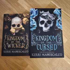 Kingdom of the Wicked och Kingdom of the Cursed av Kerri Maniscalco - Två böcker av Kerri Maniscalco: 'Kingdom of the Wicked' med ett omslag av en dödskalle och orm, och 'Kingdom of the Cursed' med en dödskalle och blå rosor. Perfekt för fantasyälskare som gillar mystik och övernaturliga element.