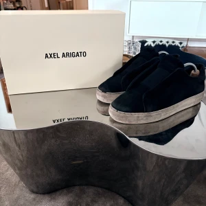 Svarta Laceless från Axel Arigato - Snygga svarta laceless skor från Axel Arigato med en stilren design. Skorna har en robust sula och är tillverkade i mocka. Köpta för nått år sedan och inte använda på ett tag. Nypris ligger på runt 2400kr