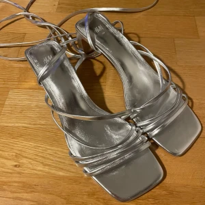 Silvriga Klackskor HM - Säljer min helt oanvända silvriga klackskor från HM i storlek 40, då dom inte kommer till användning💞