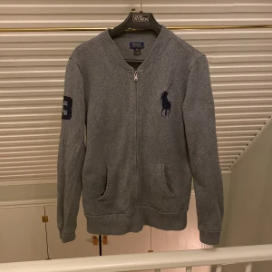 Grå Ralph Lauren Kofta - Säljer denna stilrena koftan från Ralph Lauren i färgen grå och i perfekt skick! Nypris är runt 1400kr! Kontakta gärna om du har frågor eller vill diskutera pris! Vi ses! 👋 