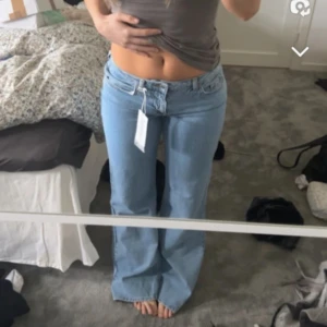 Lågmidjade jeans - Snygga  ljusblå jeans från NA-KD med bootcut-stil.  Andvända 2-3 gånger så nästan nyskick, ändats en pytte slitning vid fötterna pga för långa för mig, men inget man stör sig på. Storlek 34 men passar mig som har 36 alltid och 38 ibland. Beror på hur löst och tajt man vill att de ska sitta. 