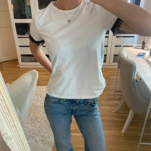 Vit t-shirt med detaljer  - Säljer en vit t-shirt med svarta detaljer på ärmen! Har knappt kommit till användning ❤️