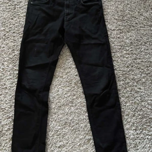 Jack & Jones Svarta jeansbyxor - Snygga svarta jeansbyxor med en klassisk design. De har en smal passform och är perfekta för en stilren look. Byxorna har fickor både fram och bak.