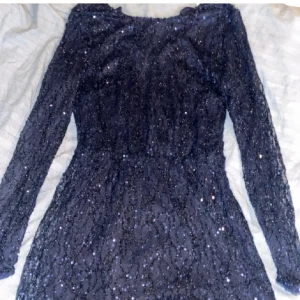 Mörkblå glittrig klänning från Nelly -  mörkblå klänning från Nelly med glittrande paljetter och långärmad design. Perfekt för festliga tillfällen. Använd ett par gånger!💓❣️