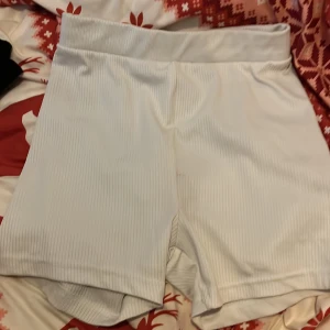 Vita ribbade shorts - Säljer ett par vita ribbade shorts med elastisk midja. Perfekta för en avslappnad stil eller träning. De är bekväma och har en stilren design (OBS har inga bilder på för dem är alldeles för små för mig har storlek medium nu).