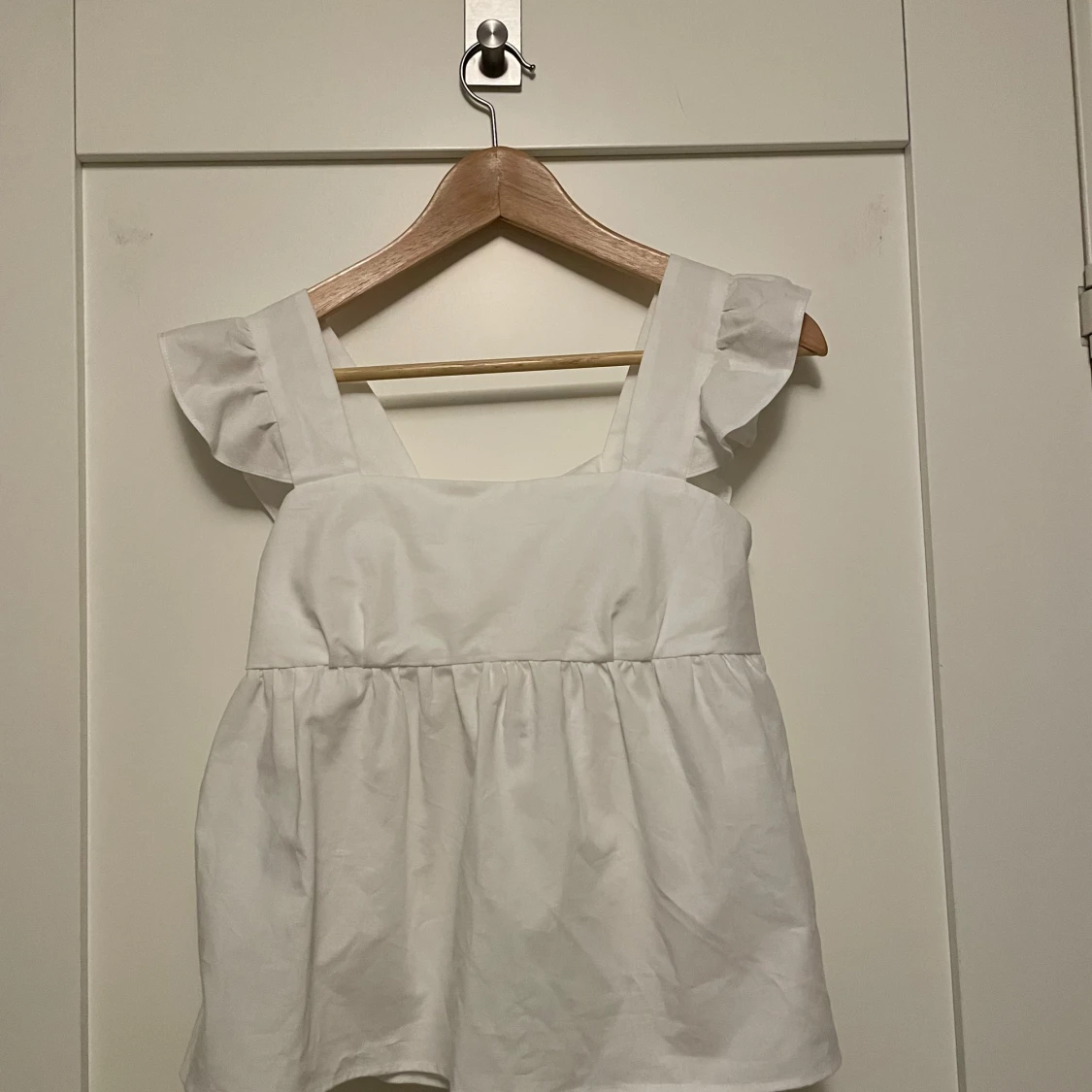 Vit topp med volangdetaljer