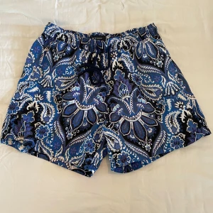 Exklusiva mönstrade badshorts från Etro - Snygga badshorts från Etro med ett unikt blått och vitt mönster. Köpta på Care Of Carl för ca. 4000kr. Helt oanvända. Perfekta för sommarens stranddagar. Tillverkade i Italien med elastisk midja för extra komfort. 