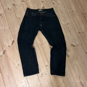 Mörkblå jeans från Acne Jeans - Snygga mörkblå jeans från Acne Jeans i 100% bomull. Klassisk design med fem fickor och knappgylf. Perfekta för en stilren look. Är rak i passformen.                                   Är öppen för bud