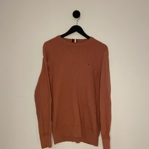 Tommy Hilfiger Tröja - Säljer en snygg rosaröd tröja från Tommy Hilfiger i ekologisk bomull. Tröjan har ett diskret märke på bröstet och en texturerad yta. Perfekt för en stilren look. Hör gärna av er vid flera frågor eller funderingar! 