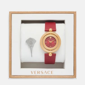 Röd klocka från Versace - Elegant röd klocka från Versace med ett guldigt boett och matchande röd urtavla. Klockan har en stilren design med romerska siffror och ett rött läderarmband. Perfekt för att ge en lyxig touch till din stil.