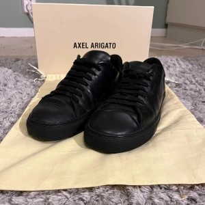 Svarta sneakers från Axel Arigato - Snygga svarta sneakers från Axel Arigato i modellen Clean 90. Tillverkade i skinn med klassisk snörning och en stilren design. Perfekta för en minimalistisk look.