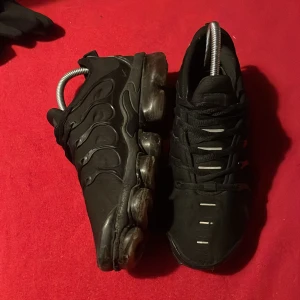 Svarta VAPORMAX  - Snygga svarta sneakers med en futuristisk design och unik sula. Skorna har snörning och en stilren look som passar perfekt för en modern stil.