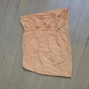 Orange kjol - Säljer en somrig orange kjol. Perfekt för varma dagar med sin lätta och luftiga design. Kjolen har en elastisk överdel för en bekväm passform.