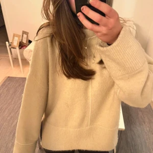 Beige stickad tröja - Mysig beige stickad tröja med långa ärmar och ribbade muddar. Perfekt för kyliga dagar och en stilren look.Den är lite noprig men de är inget man ser så mycket!☺️